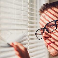 curious man looking through a jalousie