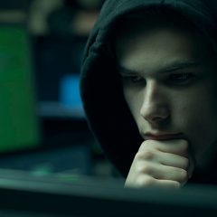 hacker with hoodie working with computers