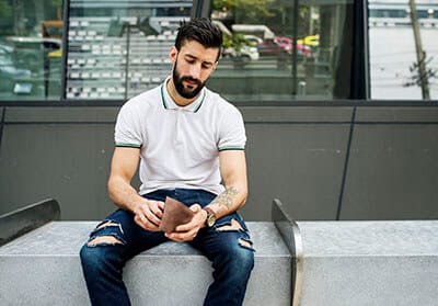 man sitting checking his money 