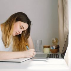 A teenage girl is drawing or doing homework in the bedroom. A teenager studies at home. Back to school