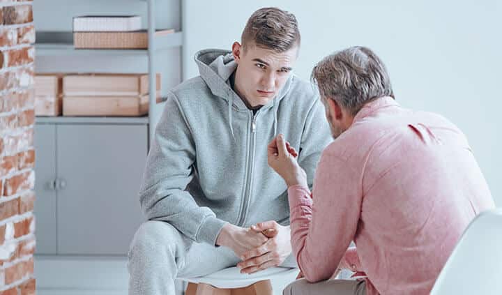 teenager talking with counselor about the security cameras